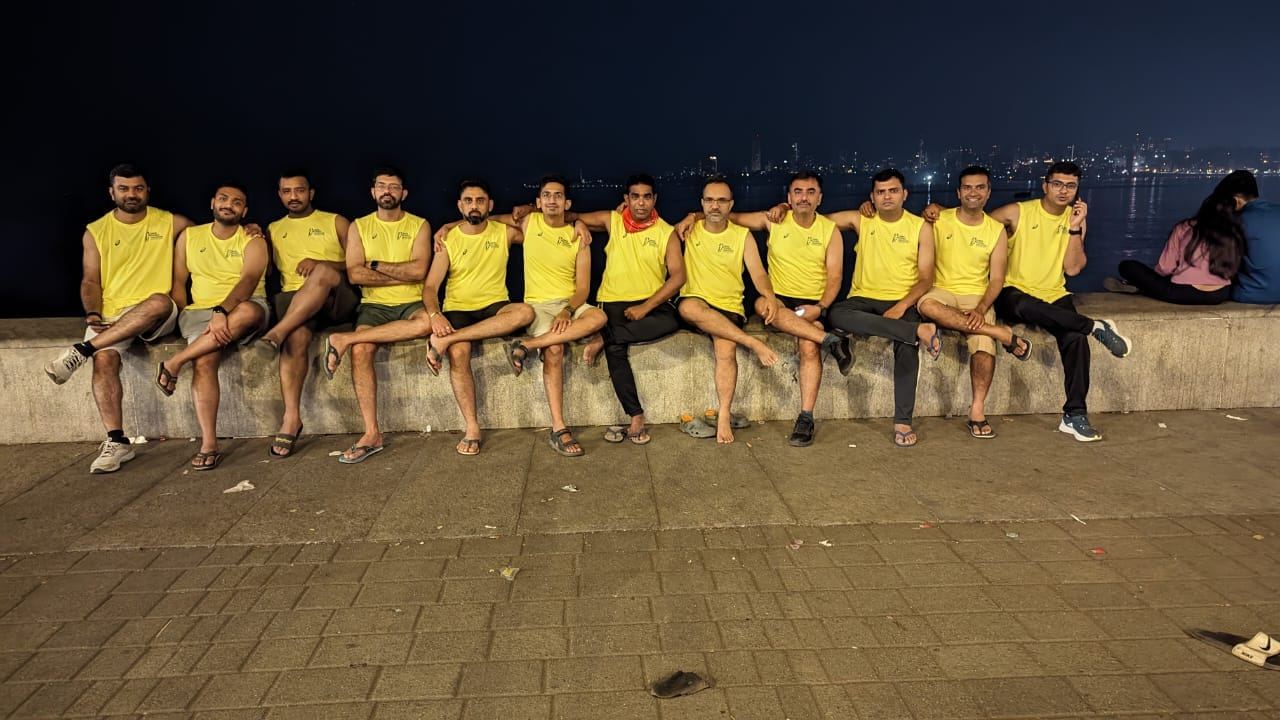 Bhuj Runners in matching club vests on a sea wall at night